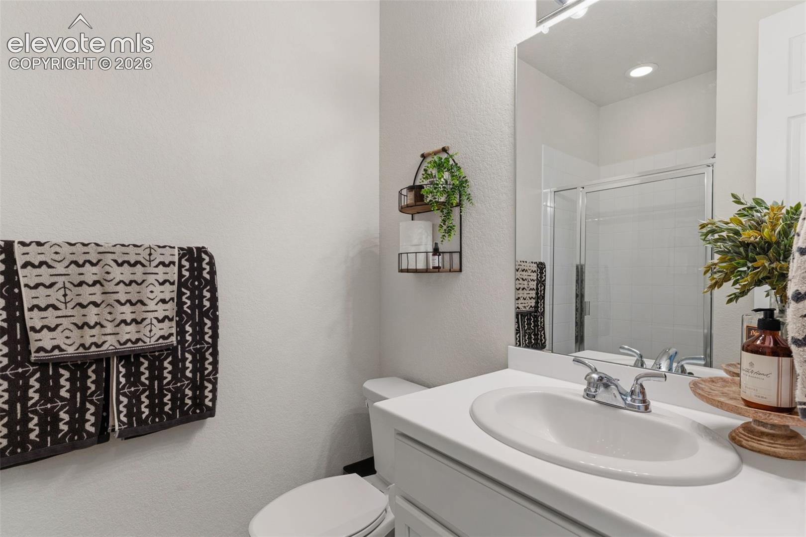 Bathroom featuring a white vanity with an integrated sink, chrome faucet, and a large wall-mounted mirror