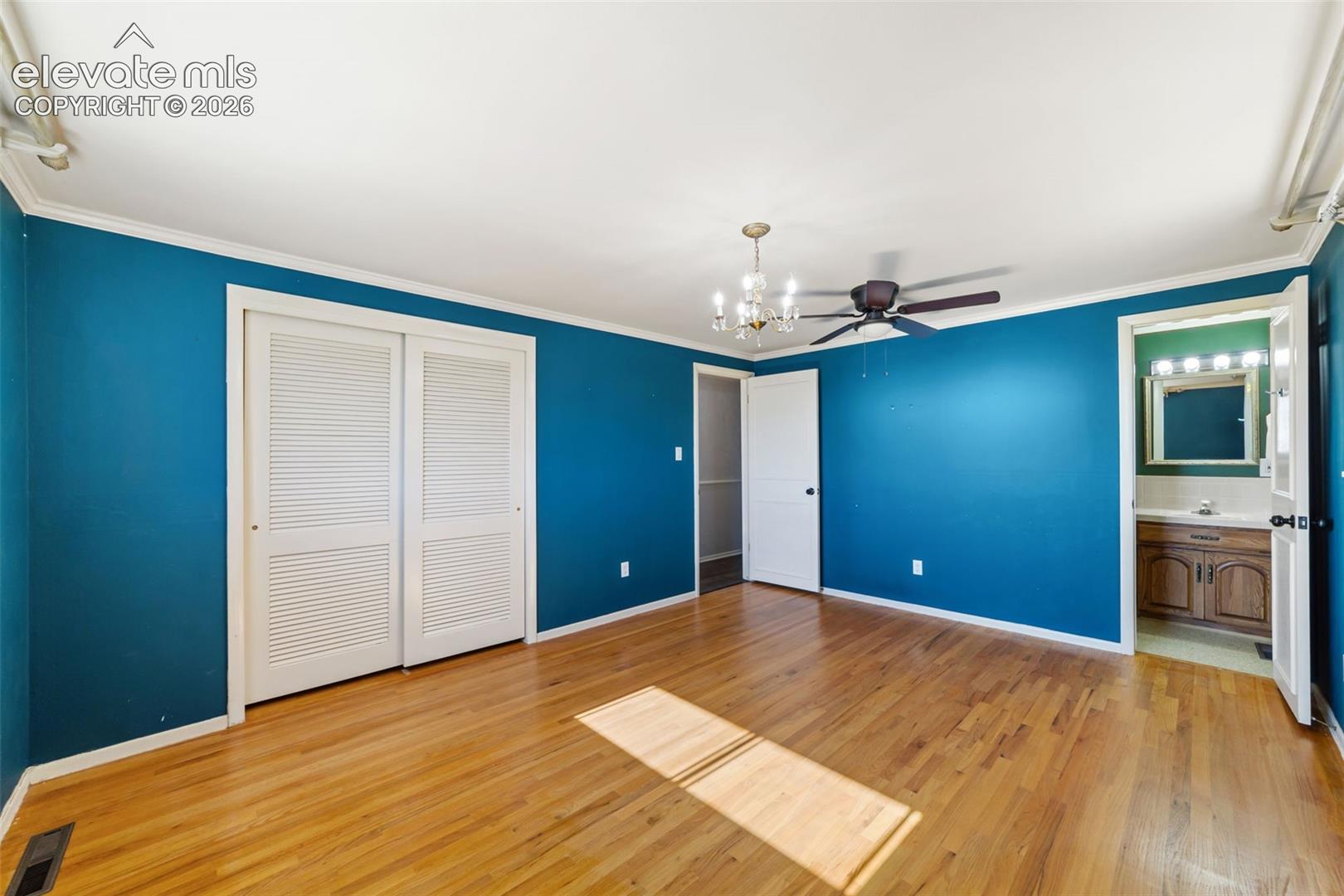 Spacious room featuring wood-finish flooring and a ceiling fan