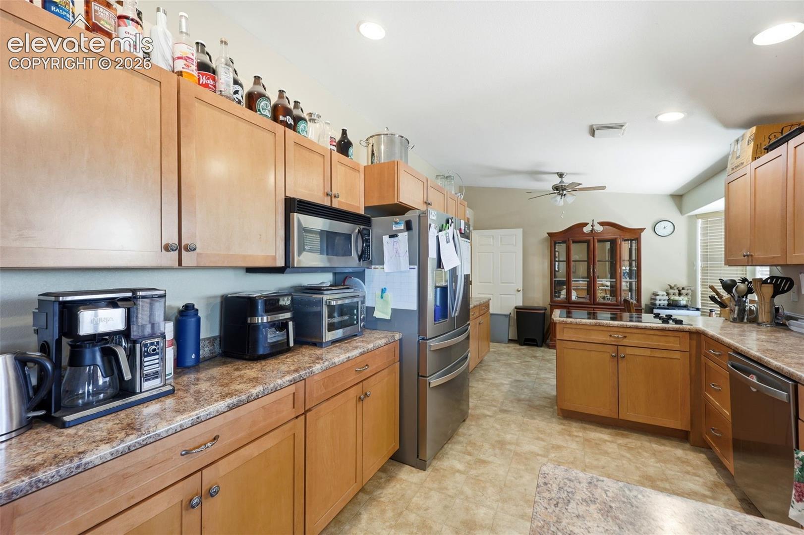 Kitchen featuring wood-finish cabinetry, speckled countertops, and tile flooring
