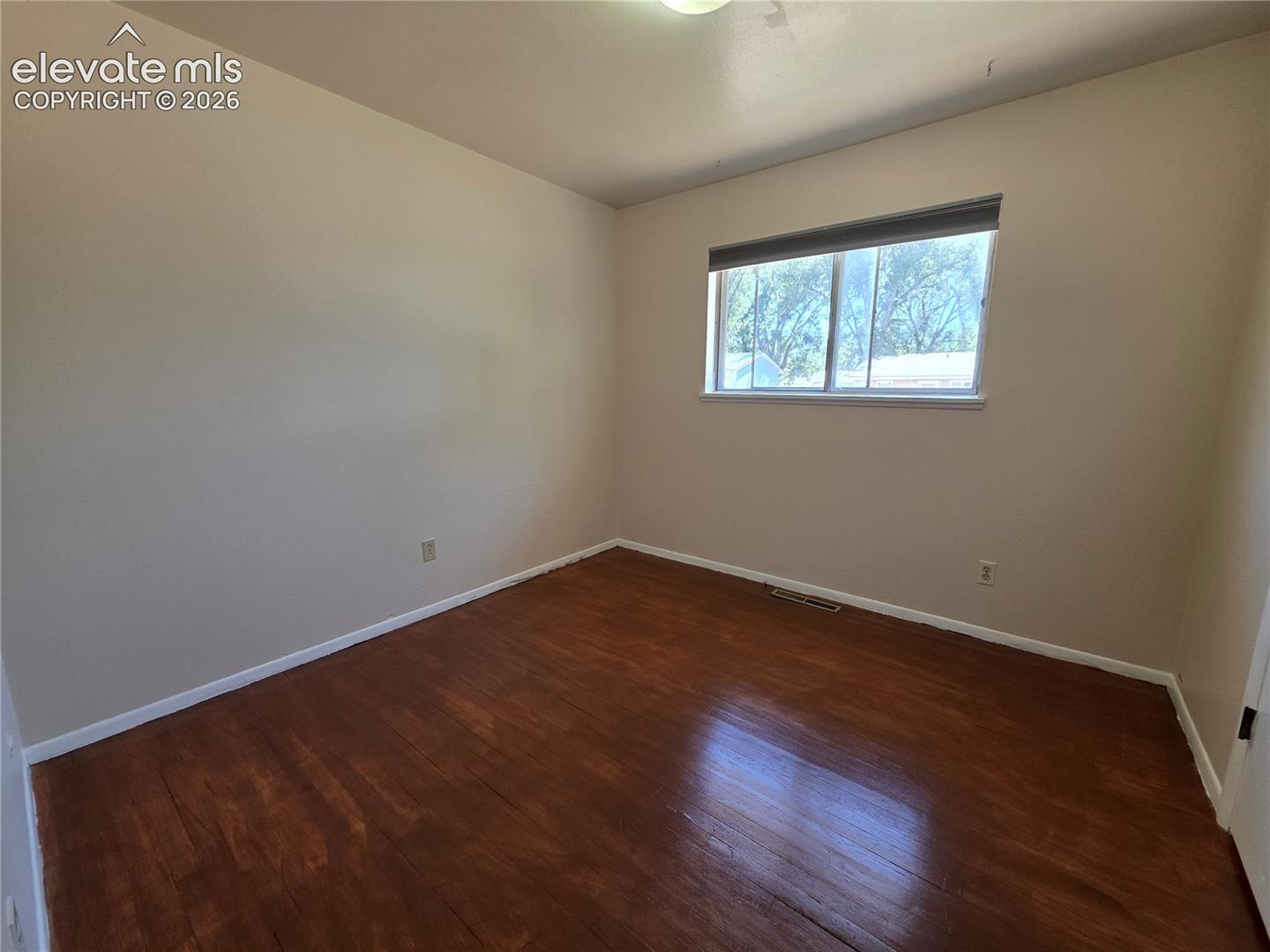 Room featuring wood-finish flooring and neutral wall tones