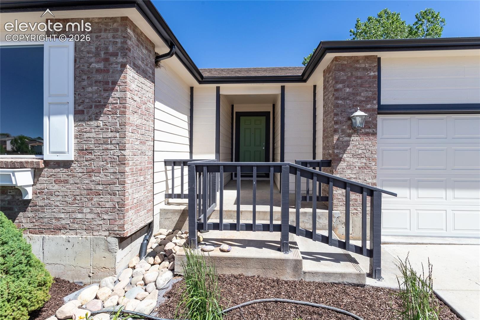 Low maintenance plants, river rock & entry railing!