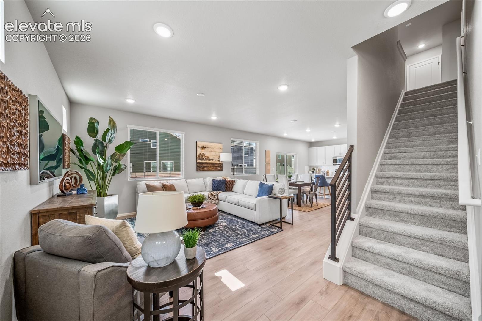 Recessed lighting, wood-finish flooring, carpeted staircase with metal and wood railing, and an open-concept layout
*photos of a model home*