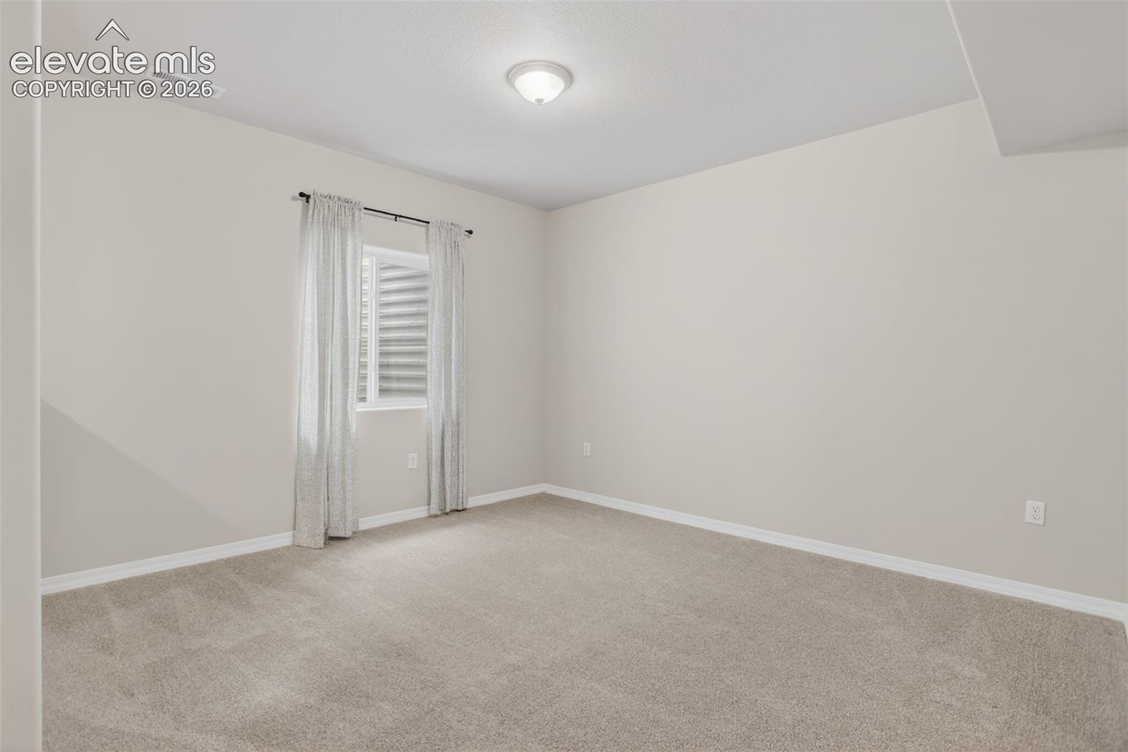 Neutral-toned wall paint throughout, complemented by light-colored carpet flooring
