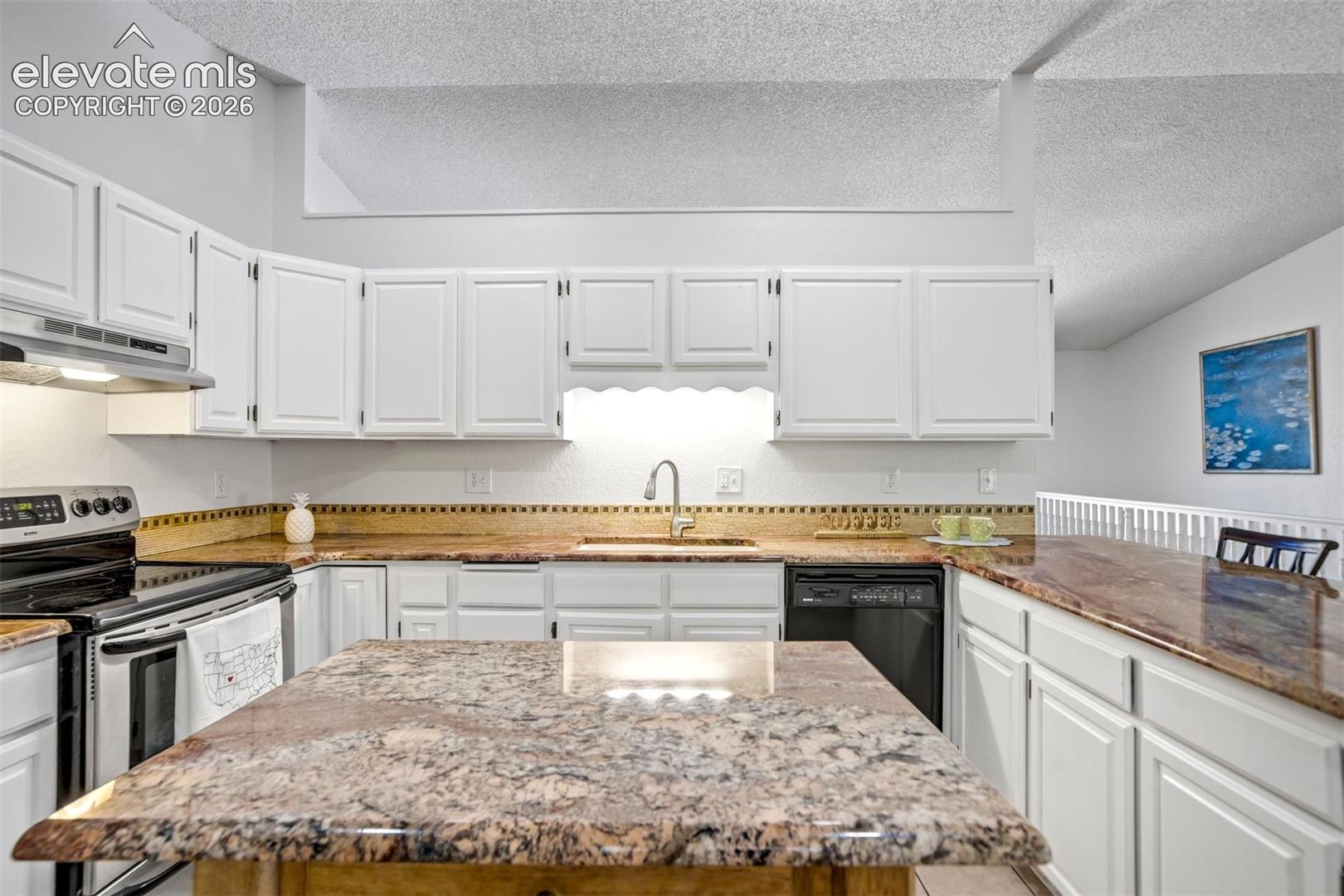 Kitchen featuring white cabinetry, stone-finish countertops, tile backsplash, stainless steel range, and a built-in dishwasher