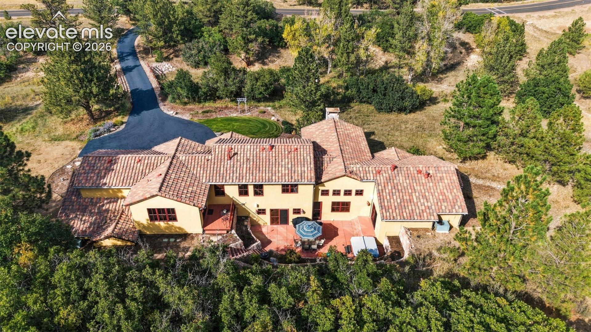 Terracotta tile roof with a yellow stucco exterior and brown window frames