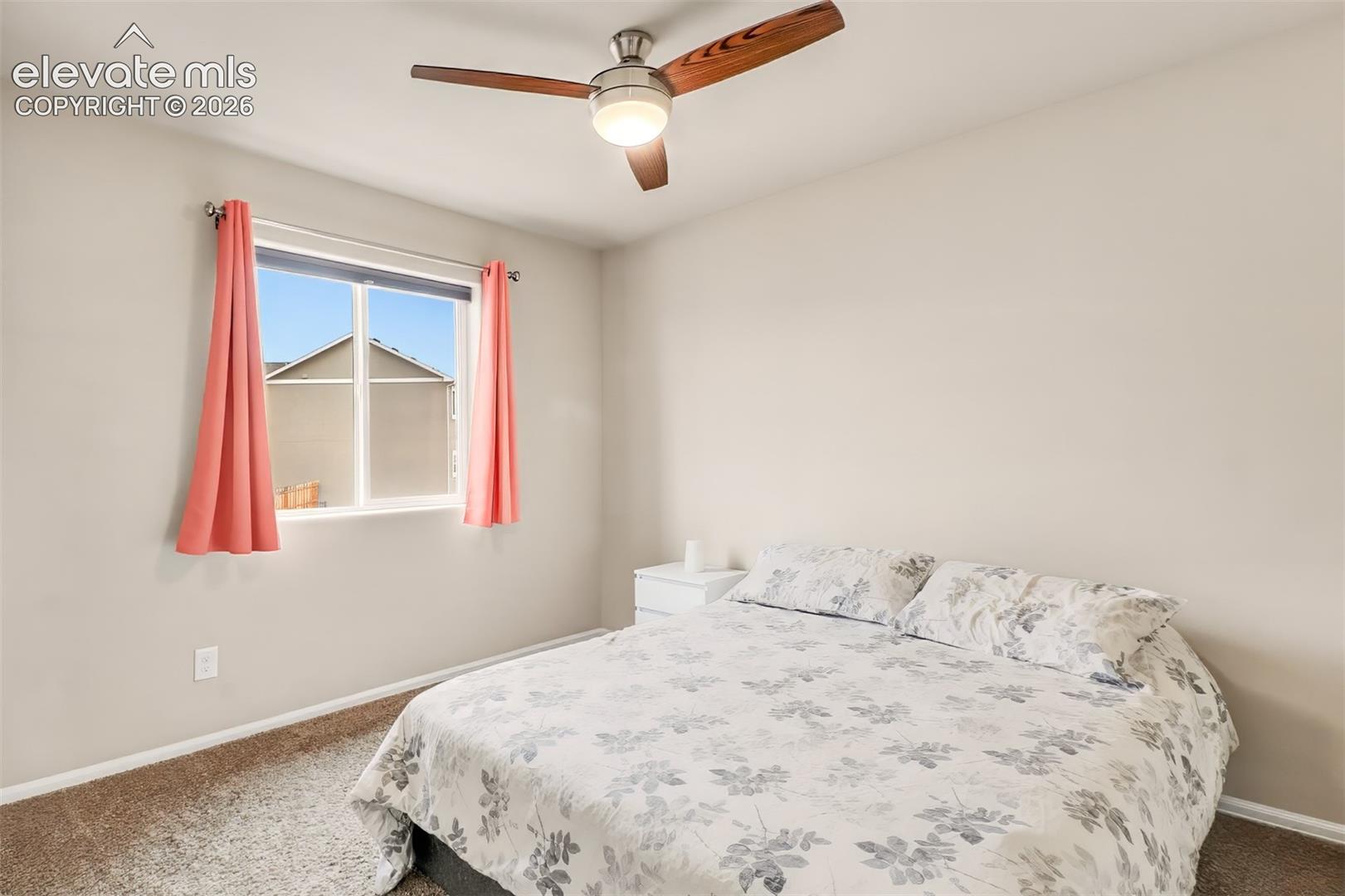 Neutral wall finishes, carpeted flooring, single-pane window, and integrated ceiling fan with central lighting