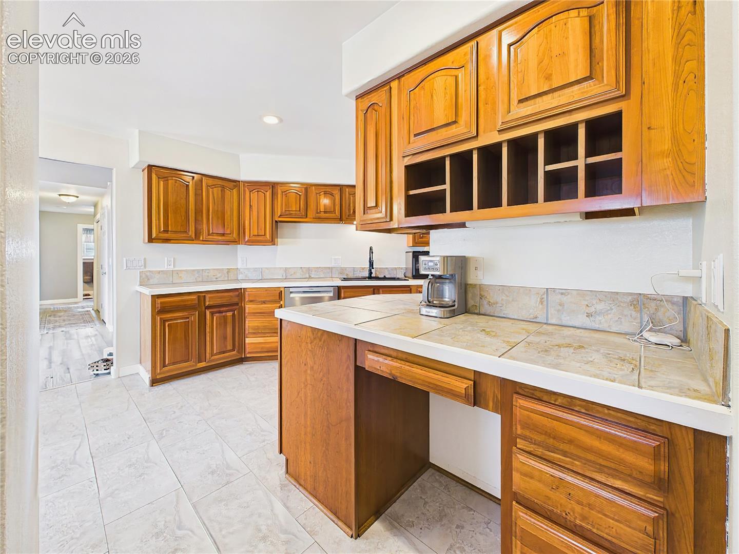 Functional butler’s pantry offers extensive cabinetry, generous counter space, and a built-in desk area, providing excellent storage and workspace.