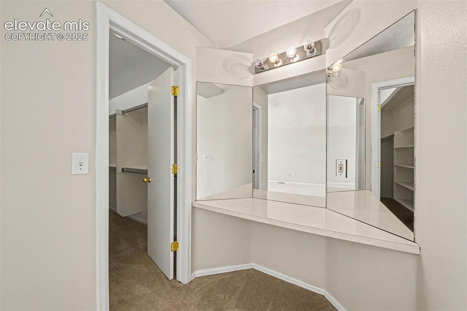 Built-in vanity with integrated mirrors and overhead lighting