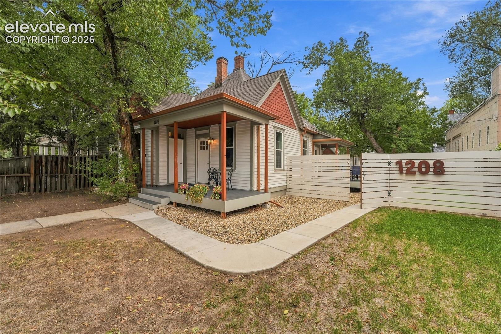 Front of main house with inviting covered front porch and fully fenced front yard.