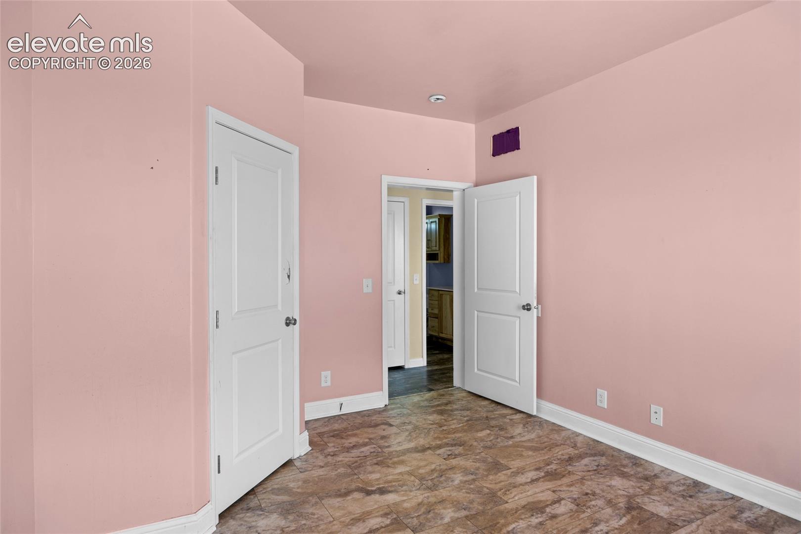 Room featuring stone-patterned flooring and two paneled interior doors