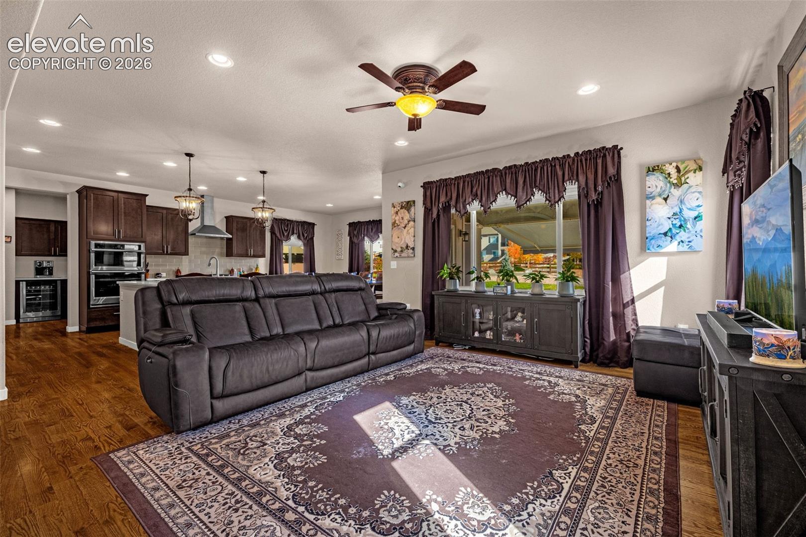 Open-concept living space featuring wood-finish flooring, recessed lighting, and a ceiling fan