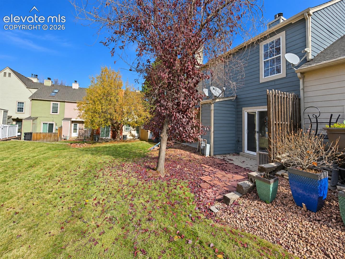 Exterior featuring lap siding, multi-story structural design, stone paver patio, and lawn area