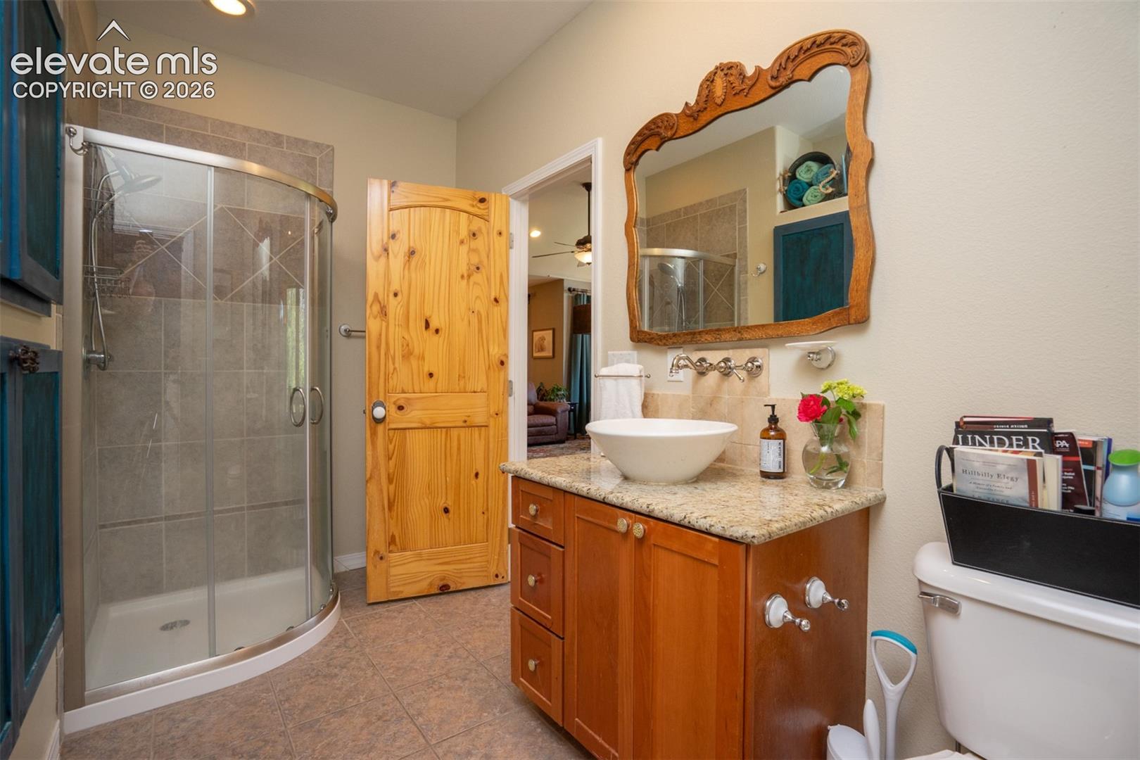 The hall bath offers a glass shower, raised sink, and great cabinet space, and it has another door to the bedroom.