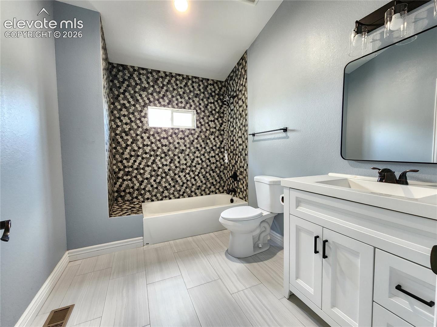 Extra large pristine full bathroom complete with a modern vanity and updated lighting