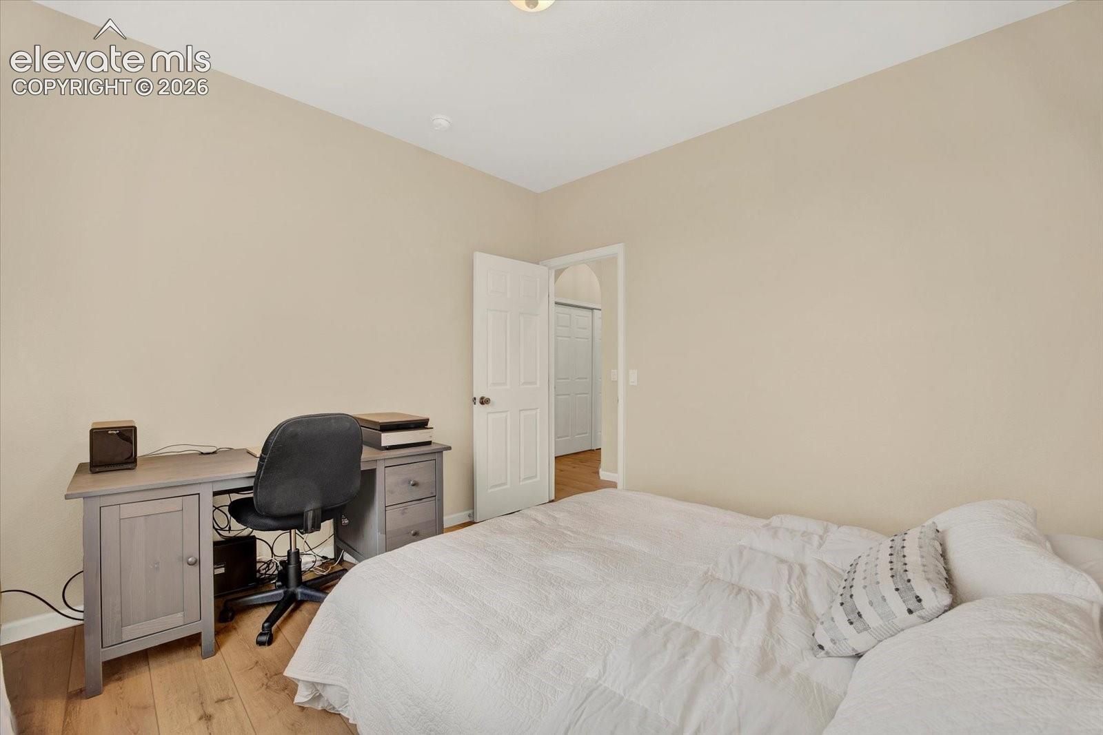 Neutral-toned interior space featuring wood-finish flooring and a six-panel interior door