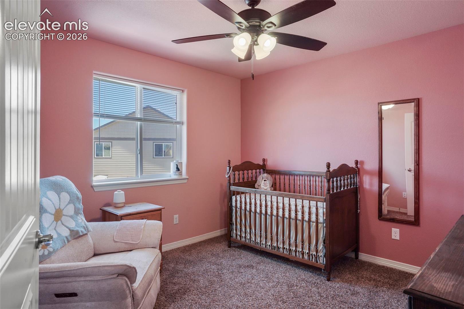 Recessed window with blinds, ceiling fan with integrated lighting, and carpeted flooring