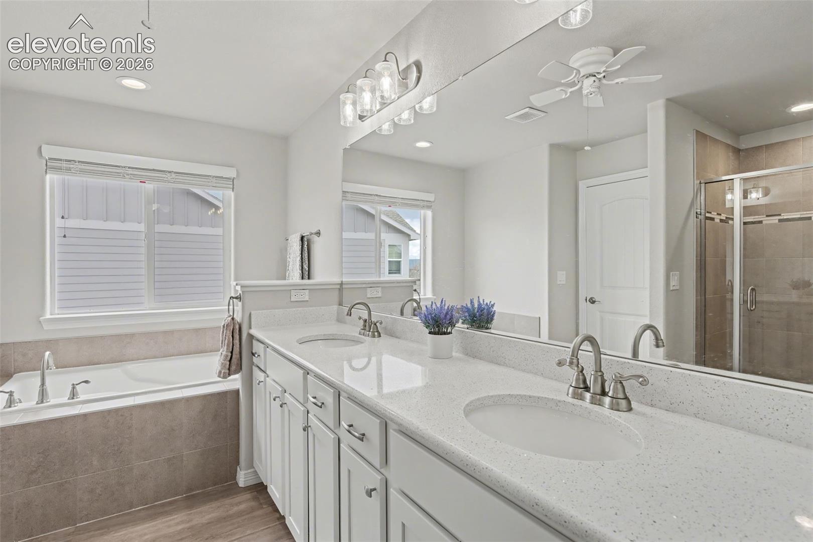 Dual vanity with integrated sinks, white cabinetry, and light-toned countertops