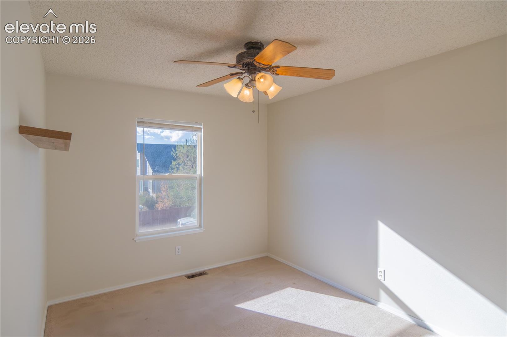 Natural light, a ceiling fan, and a neutral palette make this bedroom easy to personalize.