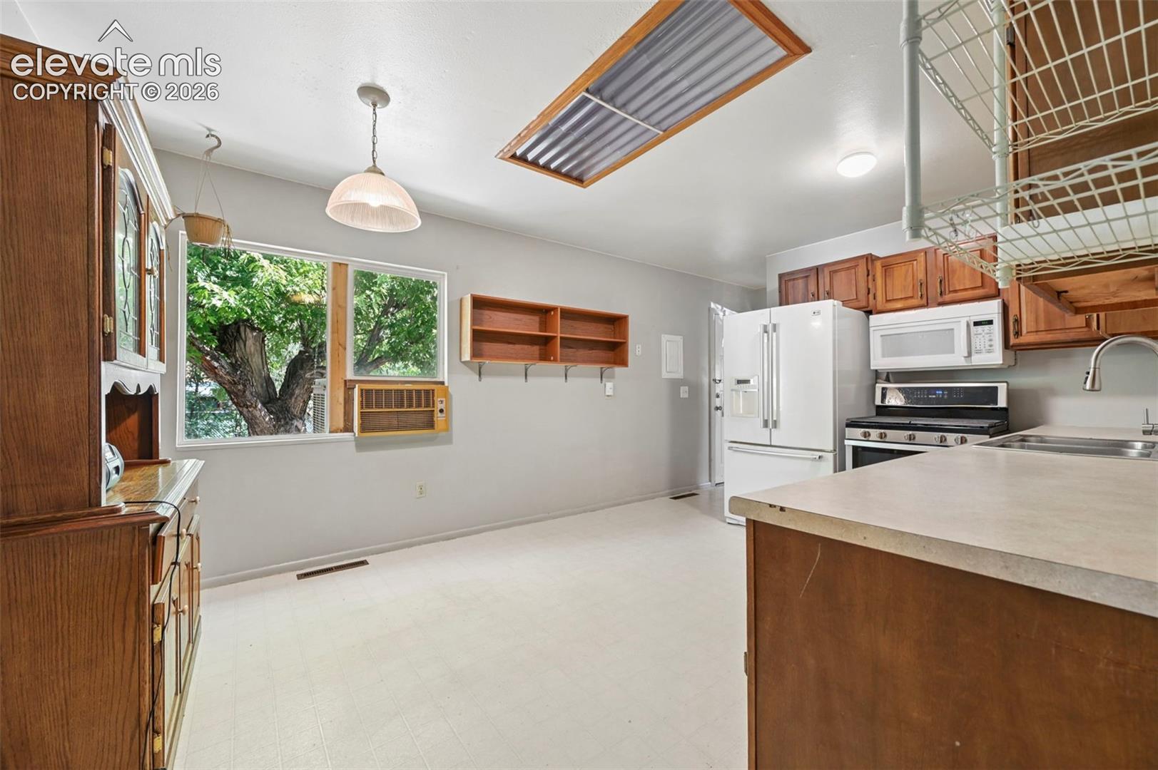 Kitchen area with light-toned flooring and white walls