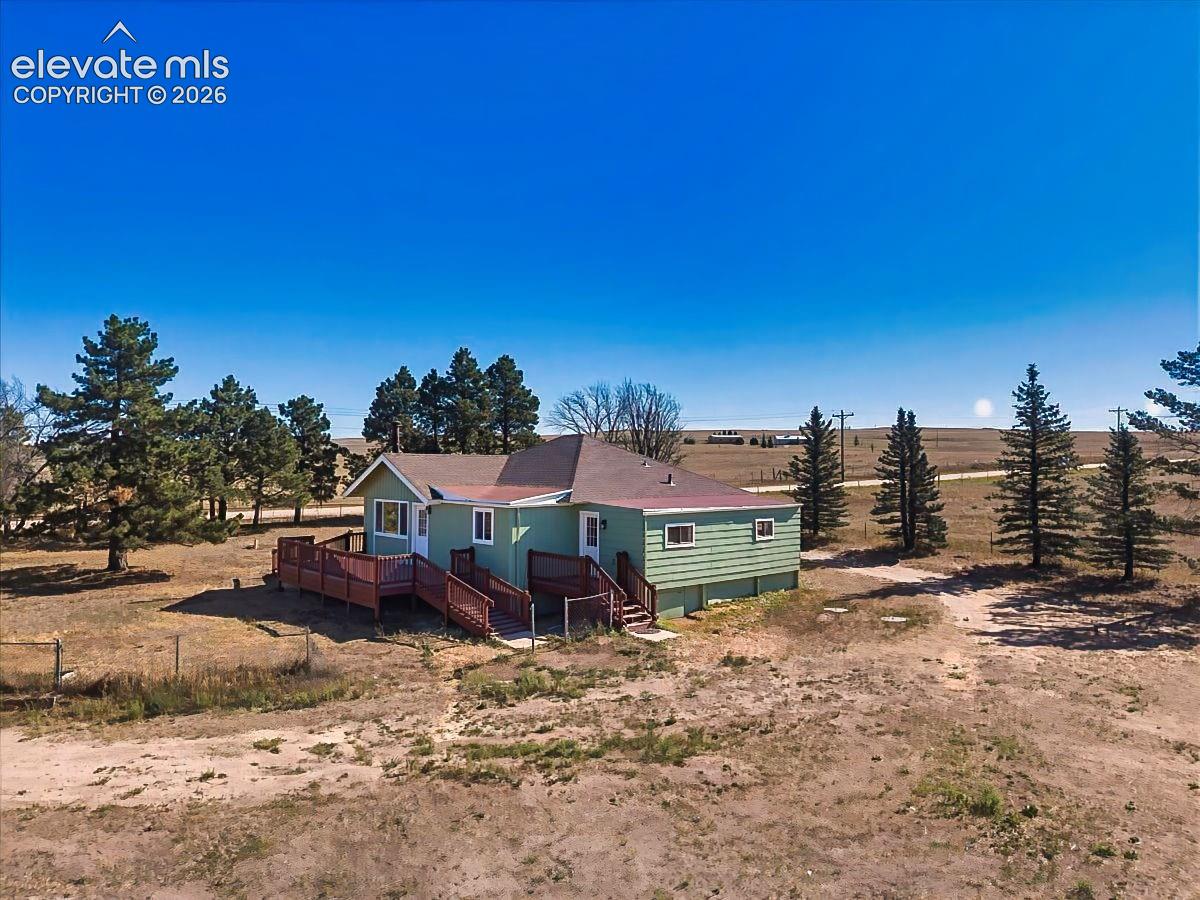 Aerial View – Elevated aerial view showcases the home's spacious setting, mature trees, multiple outbuildings, and expansive surrounding acreage.