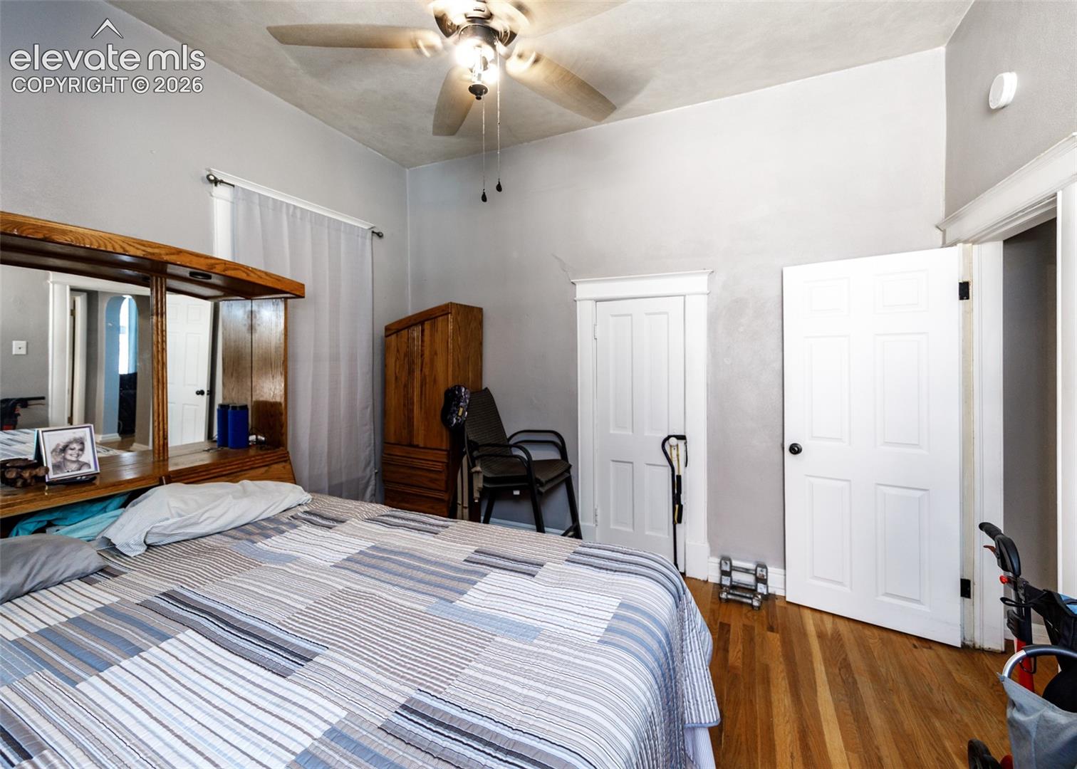 Hardwood flooring, painted walls, ceiling fan with light fixture, and white paneled doors
