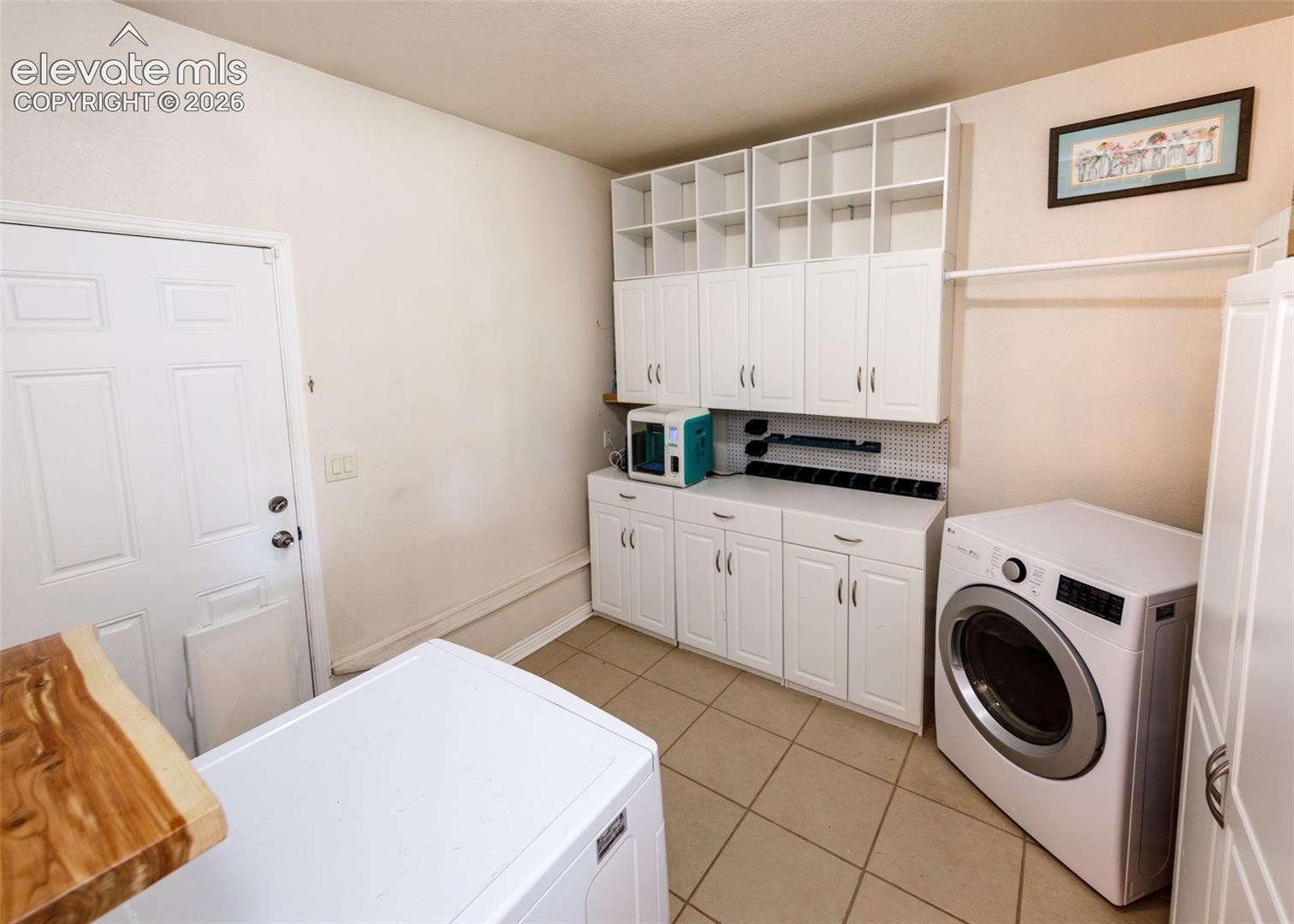 White cabinetry with integrated shelving provides extensive storage