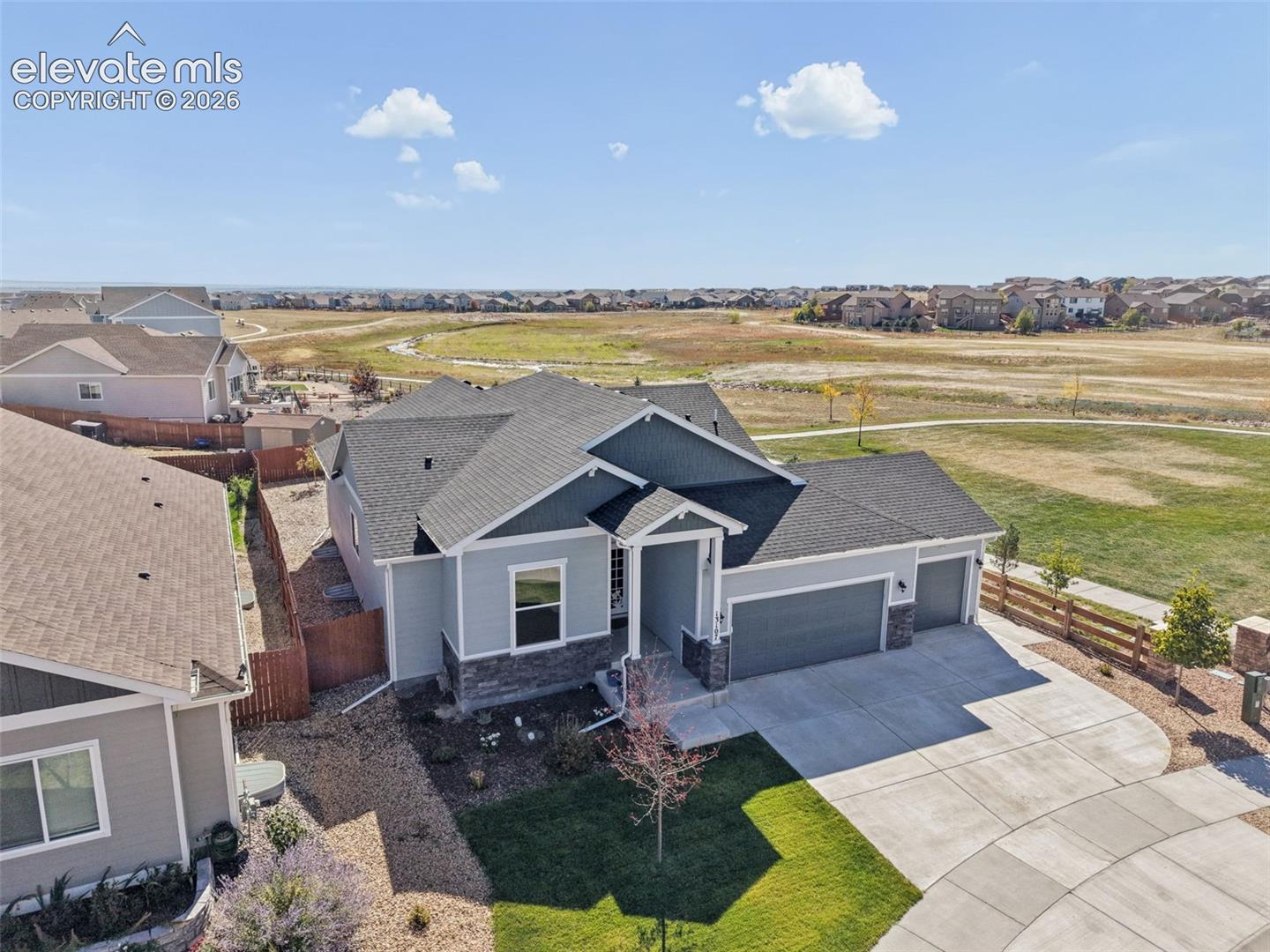 Single-story residence featuring composite shingle roofing, horizontal lap siding, stone veneer accents, and a three-car garage