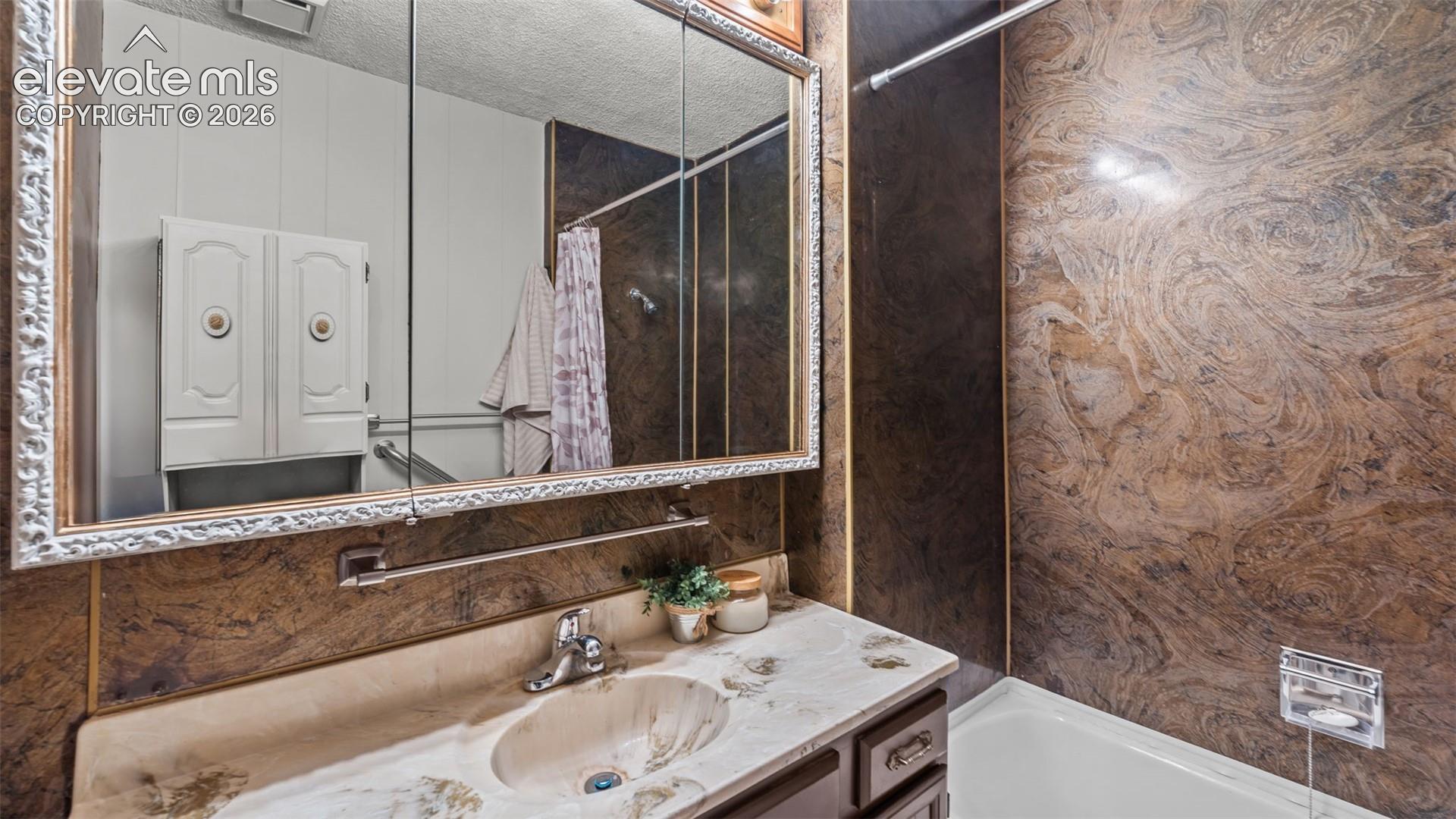 Contemporary bathroom featuring a double vanity with dual vessel sinks, brushed nickel faucetry, and a stone-finish countertop