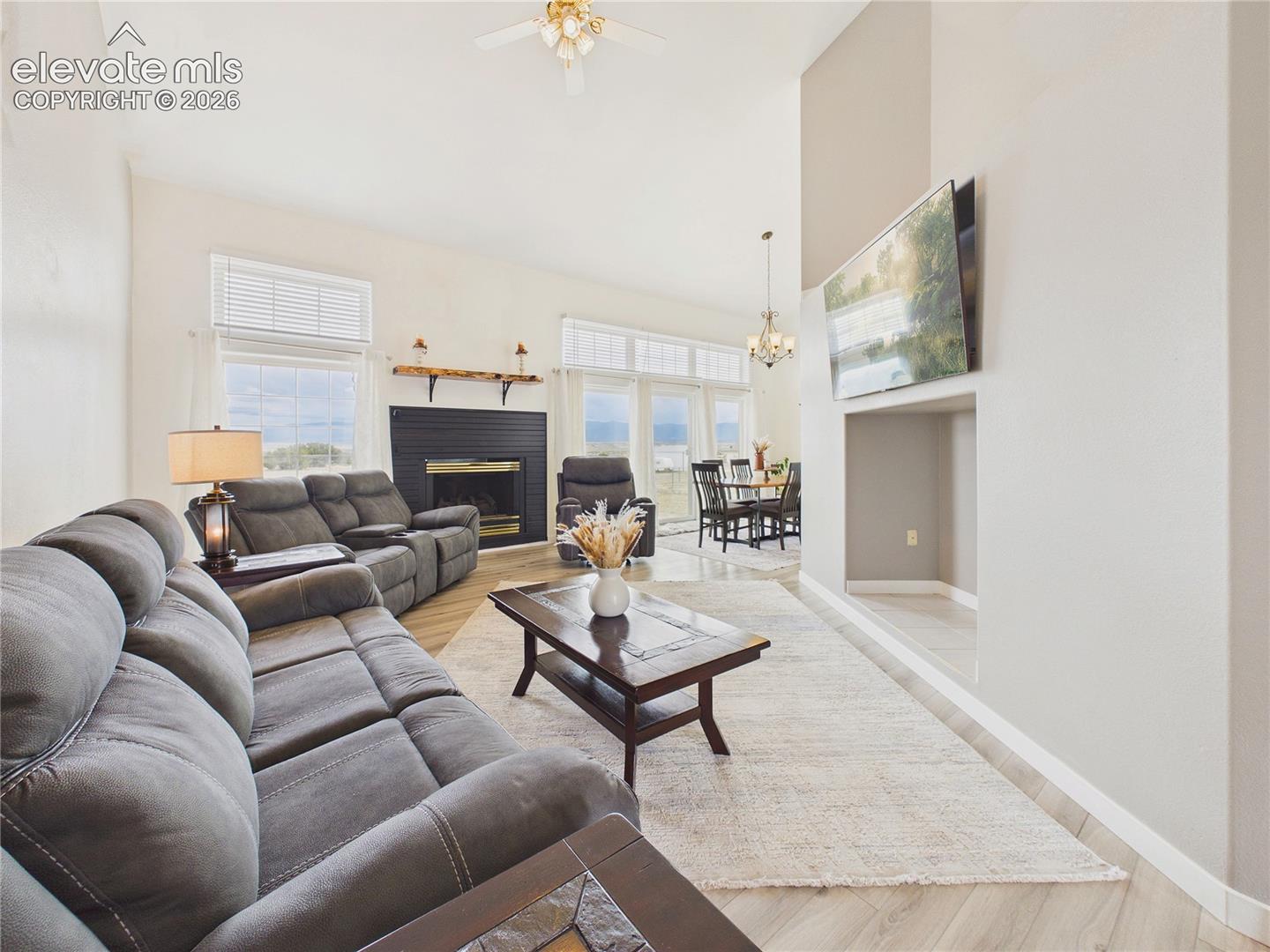 Bright and inviting living room features soaring vaulted ceilings, updated flooring, and expansive windows that showcase stunning mountain views.