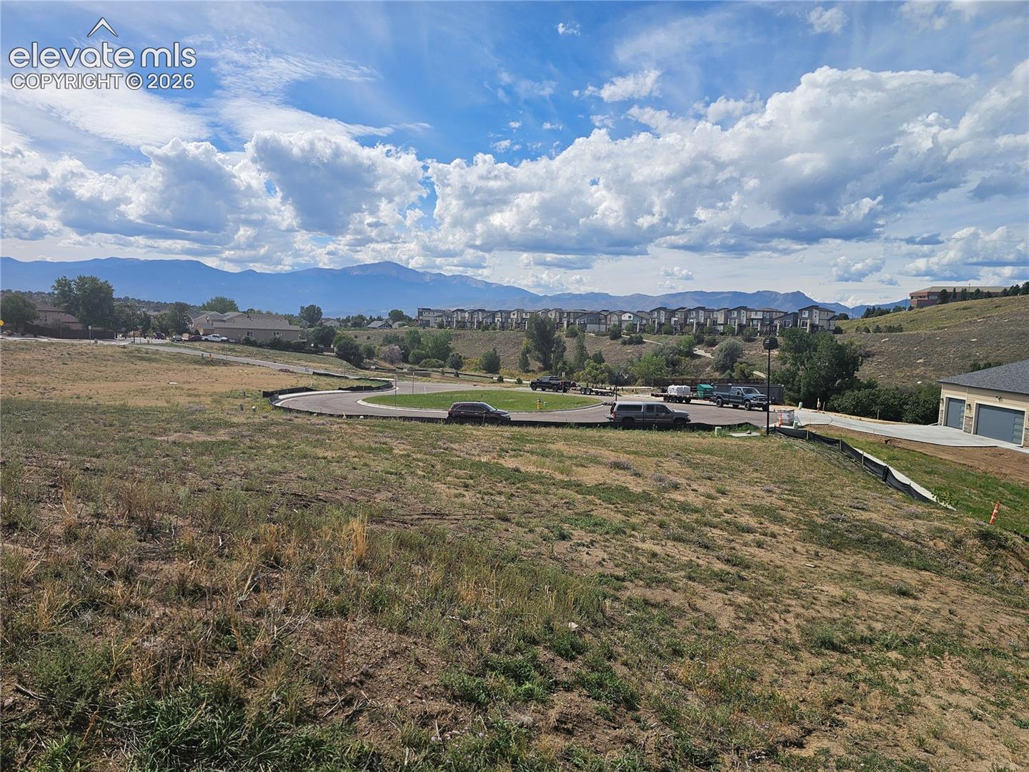 Undeveloped lot featuring a prominent mountain backdrop, rolling topography, and paved street access