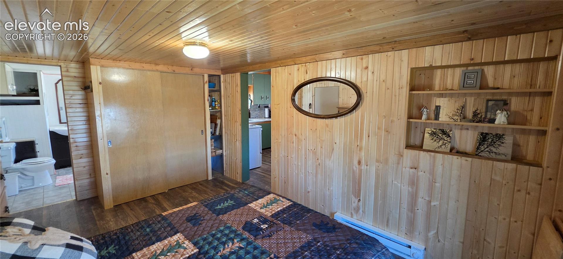 Wood paneling throughout, built-in shelving, wood-finish flooring, recessed lighting, and a sliding closet door