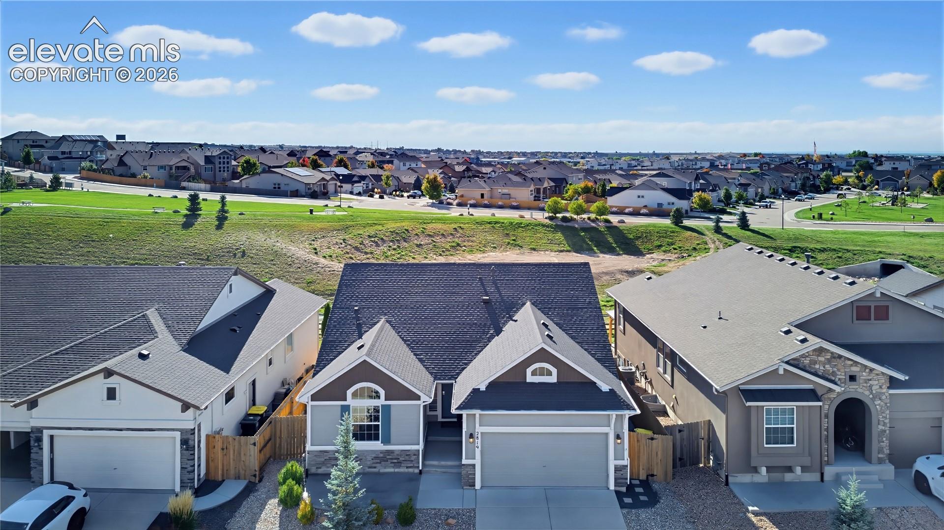 Single-family residence featuring a composite shingle roof, stone veneer accents, multi-pane windows, an attached two-car garage, and concrete driveway