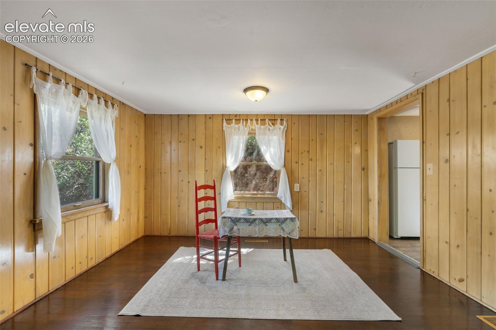 Interior space featuring wood-paneled walls and dark wood-finish flooring