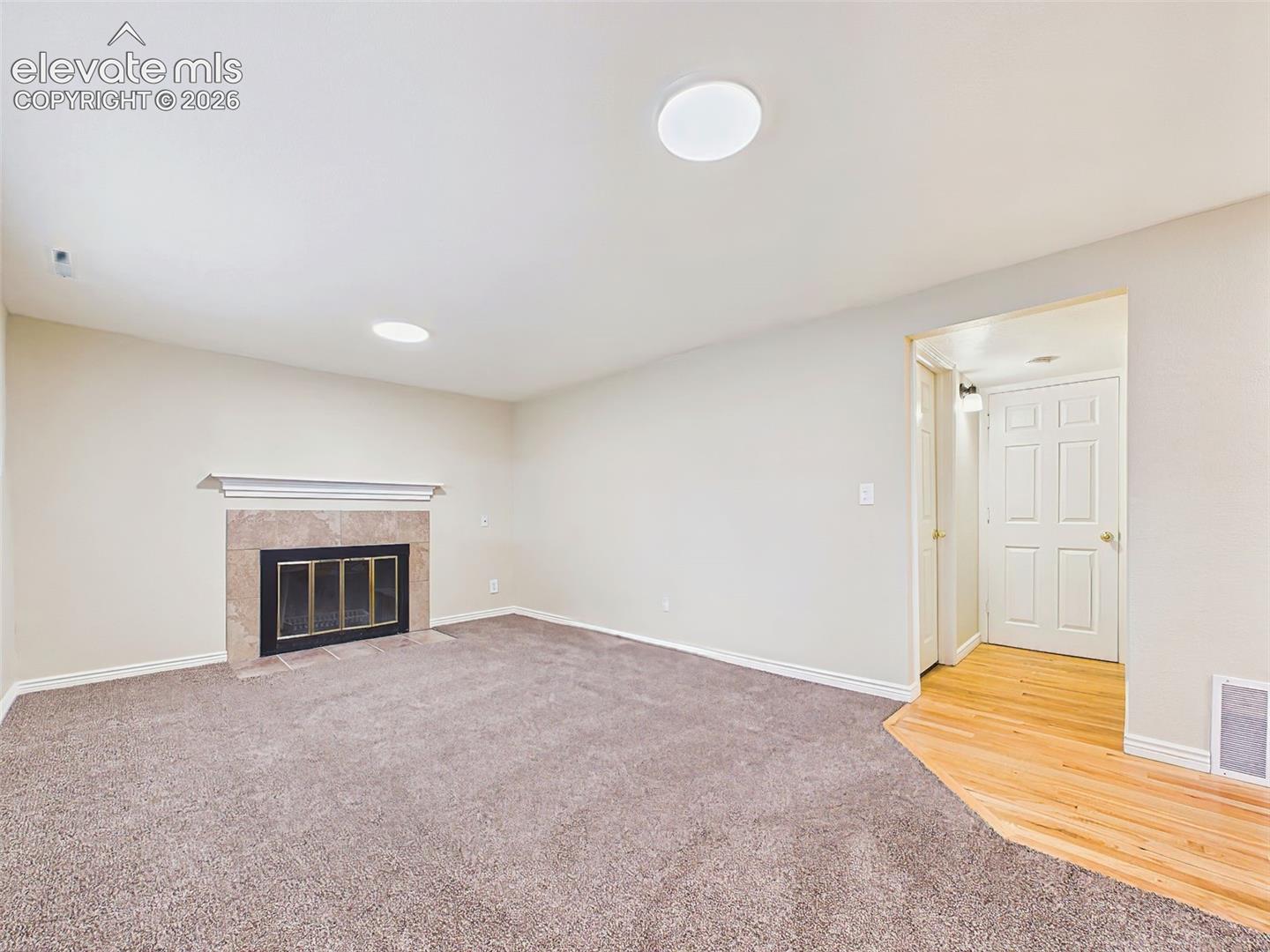 Family Room – Spacious lower-level family room featuring brand-new carpet, recessed lighting, and a cozy tile-surround fireplace that creates a warm gathering space.