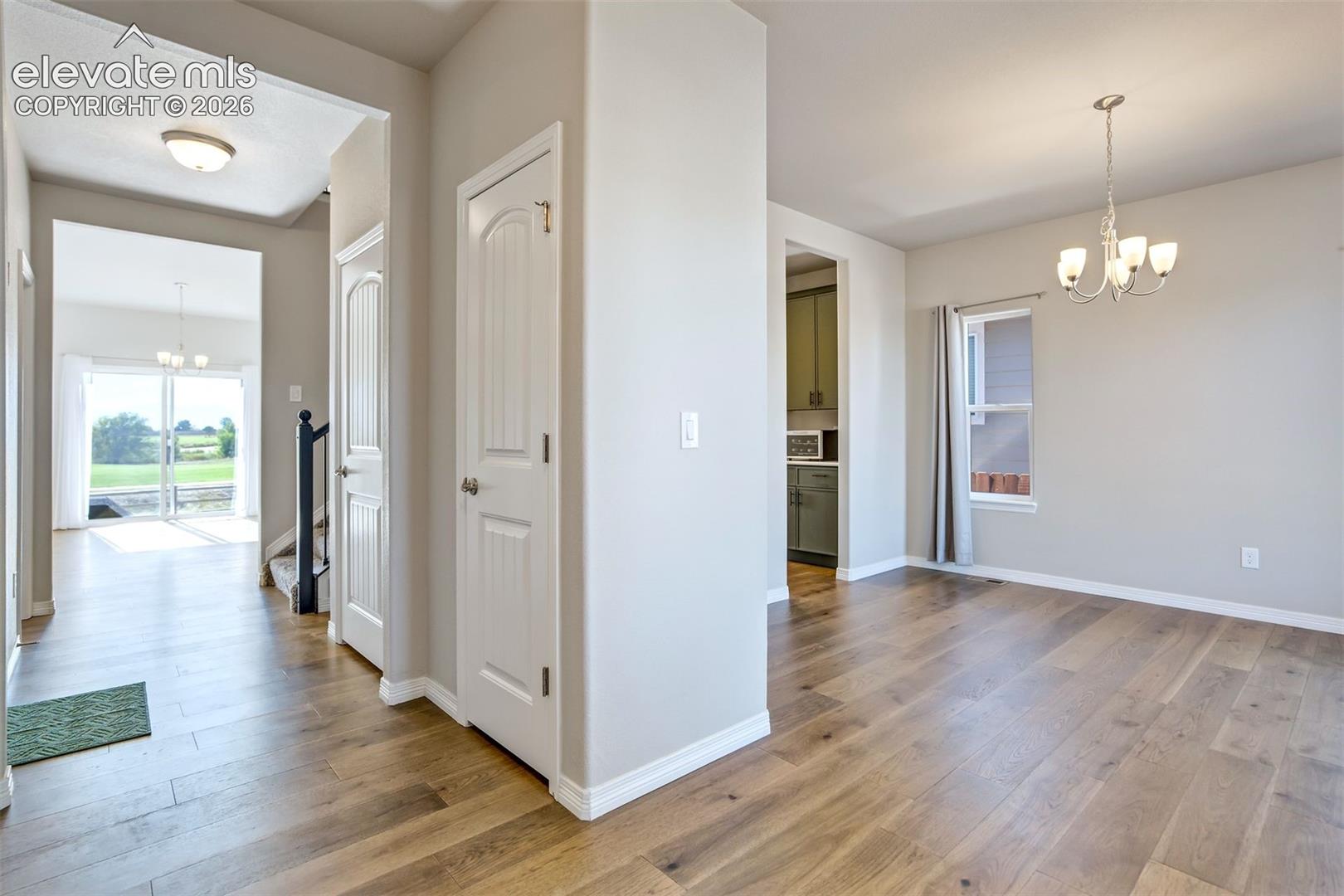 Wood-finish flooring throughout, white trim, and light gray wall color