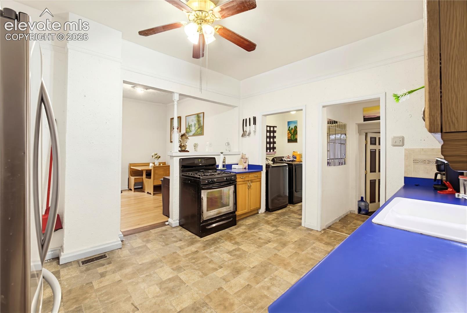 Kitchen with patterned tile flooring, blue countertops, and wood-finish cabinetry