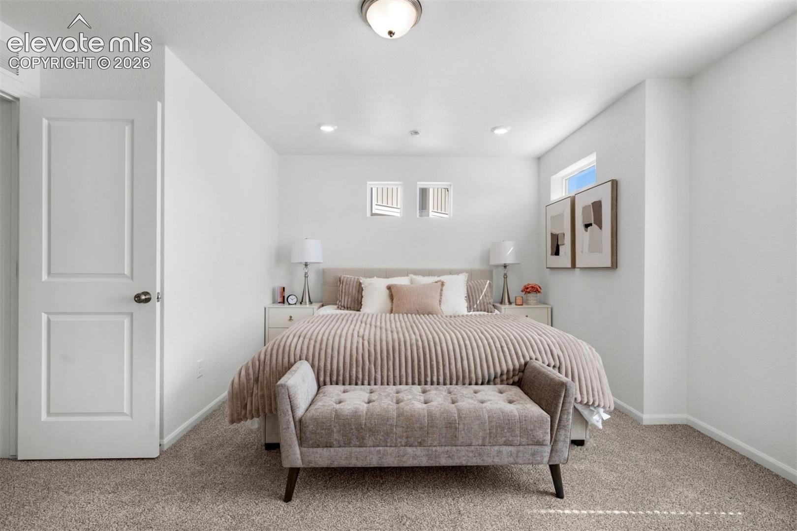 Carpeted flooring, white walls, flush mount ceiling light, recessed lighting, and a white two-panel door
*photos of a model home*