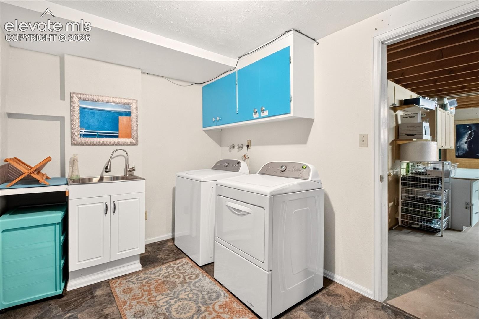 Ihe laundry area comes complete with washer, dryer, sink, and loads of storage!