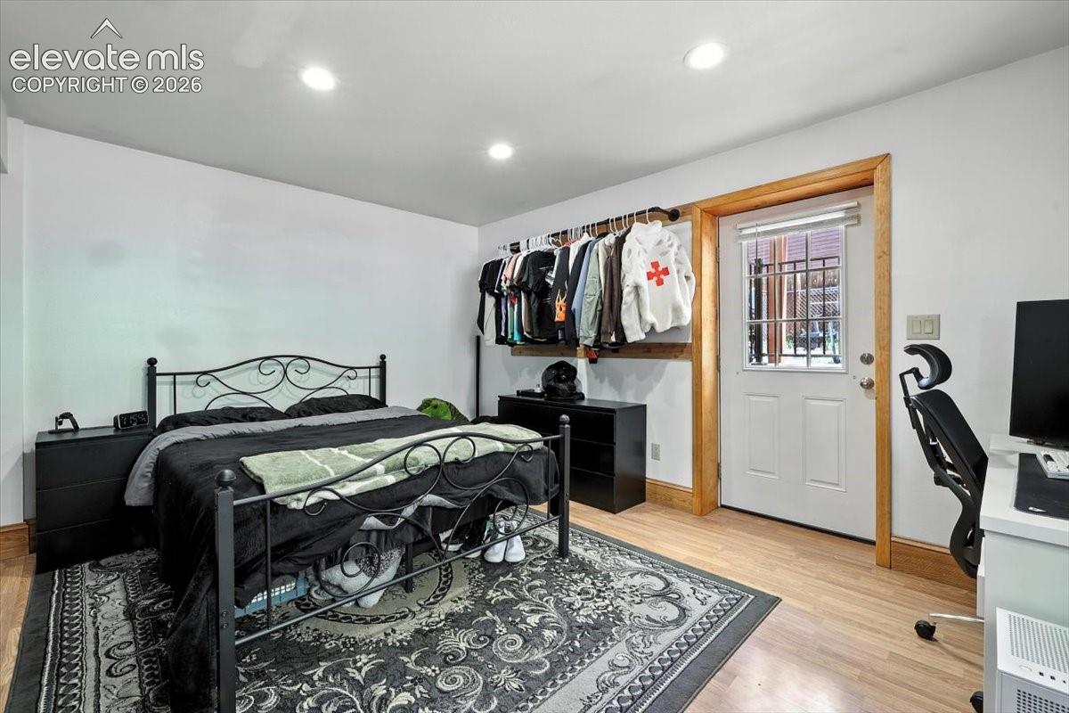 Interior space featuring recessed lighting, light-tone wood-finish flooring, and a glass-paneled exterior door framed in natural wood trim