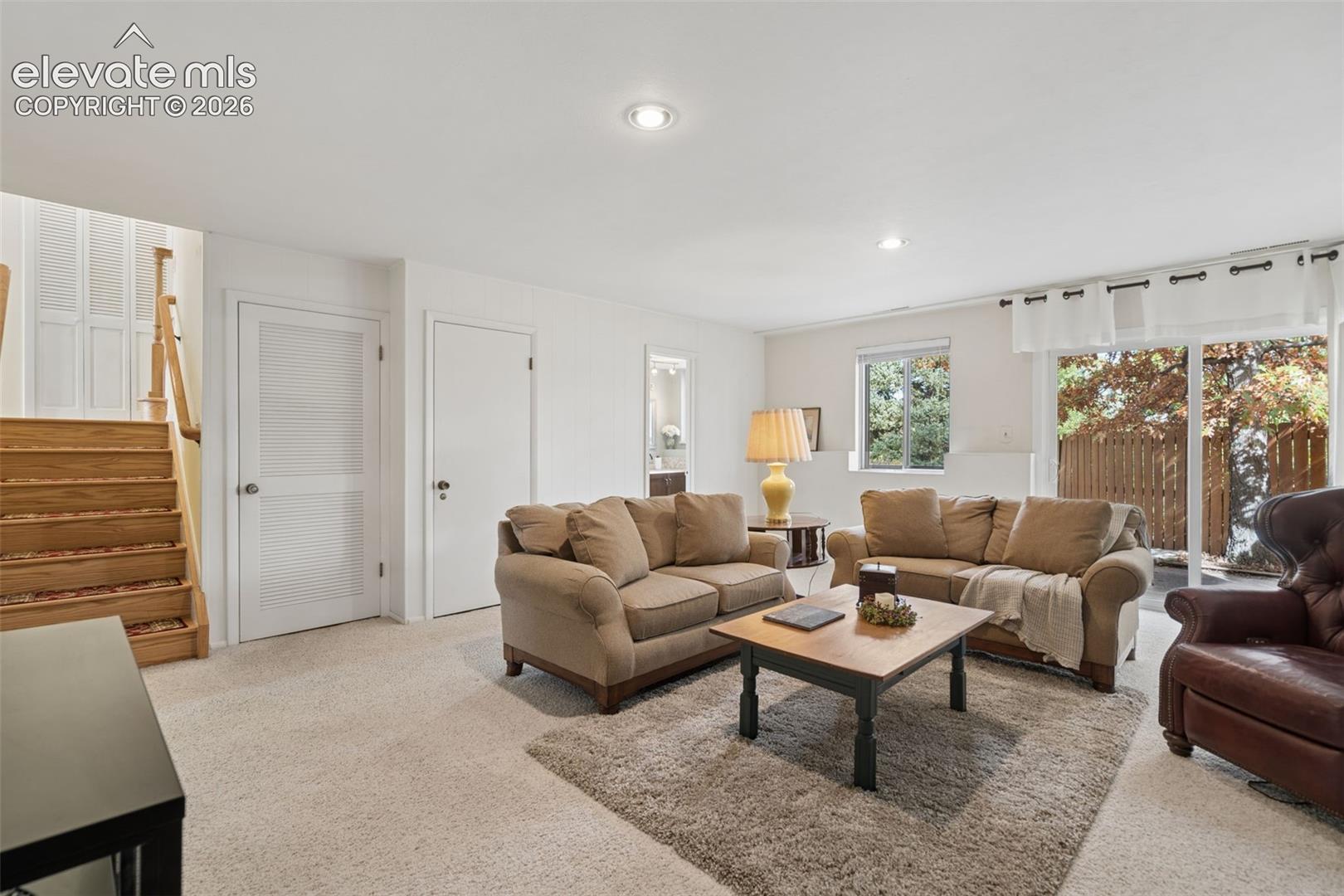 Lower level entertainment area with full walkout unto patio. Door on left leads to the basement, middle door is a spacious closet, and door on the right is 3/4 bathroom.