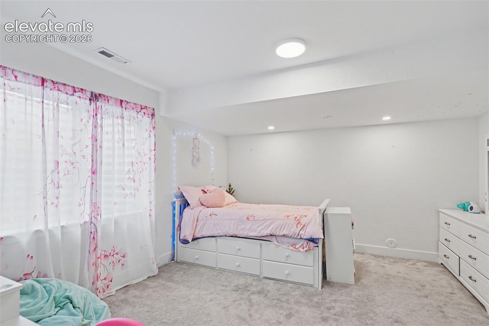 Bedroom with light colored carpet and recessed lighting