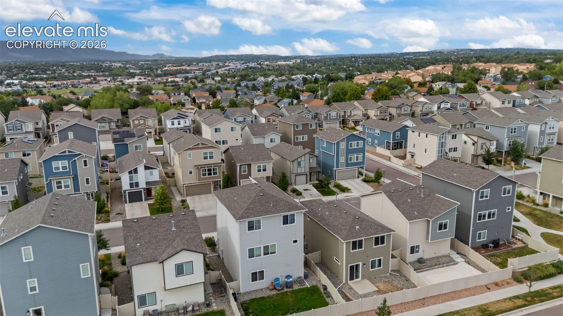 Residential neighborhood with varied architectural styles, asphalt shingle roofs, and paved streets