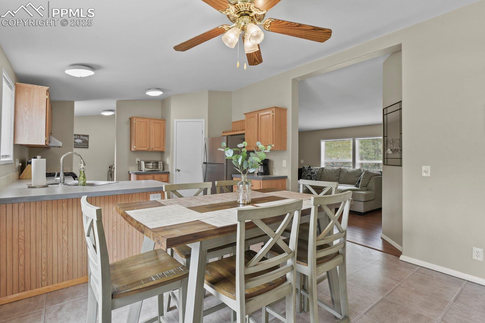 Dining space featuring light tile patterned floors and a ceiling fan