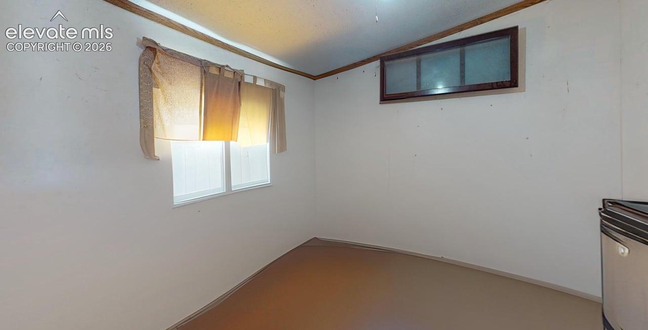 Empty room featuring crown molding