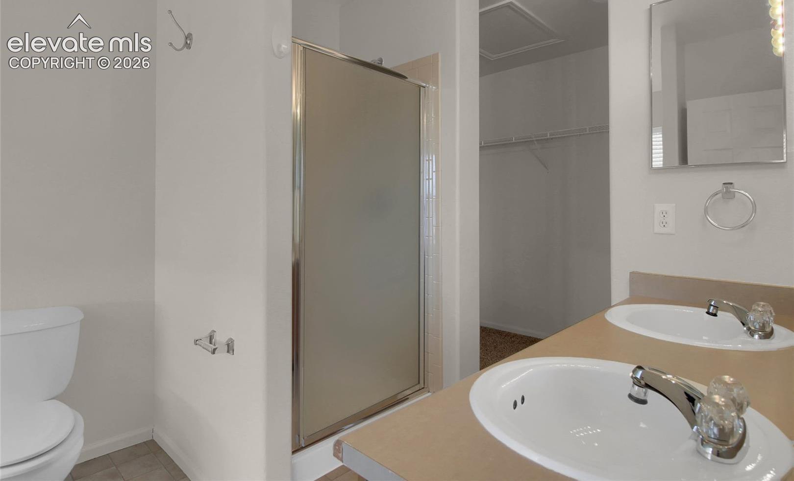 When vacant primary bath facing shower and walk in closet