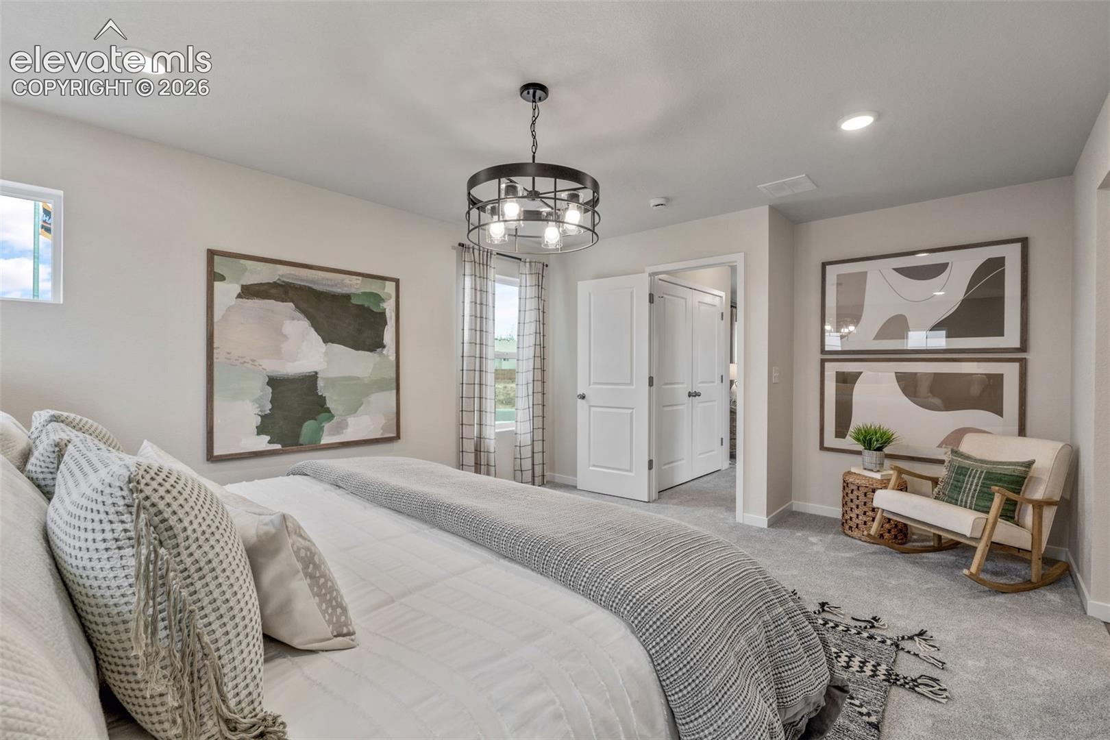 Recessed lighting, a centered chandelier, wall-to-wall carpeting, and white paneled doors