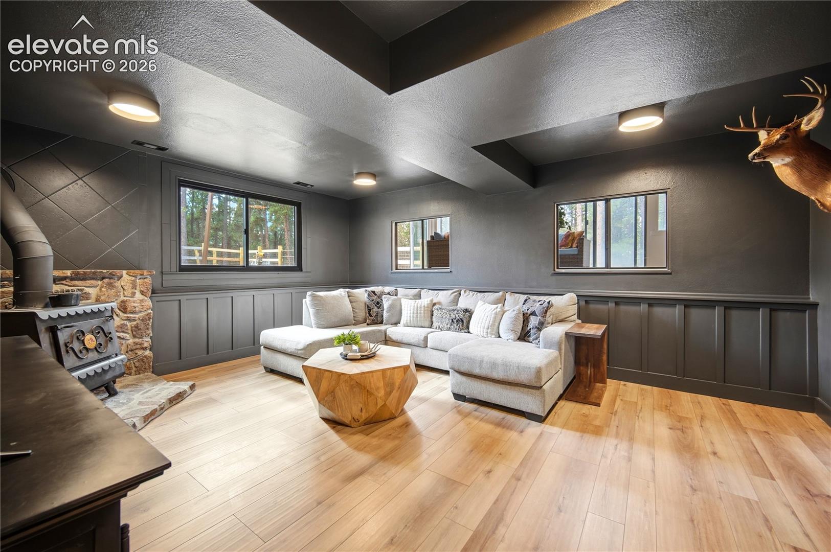 Wood-finish flooring, wainscoting, stone-surround wood-burning stove, and recessed lighting