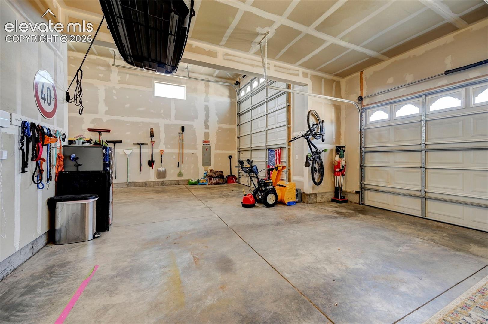 Spacious garage featuring concrete flooring and two overhead garage doors