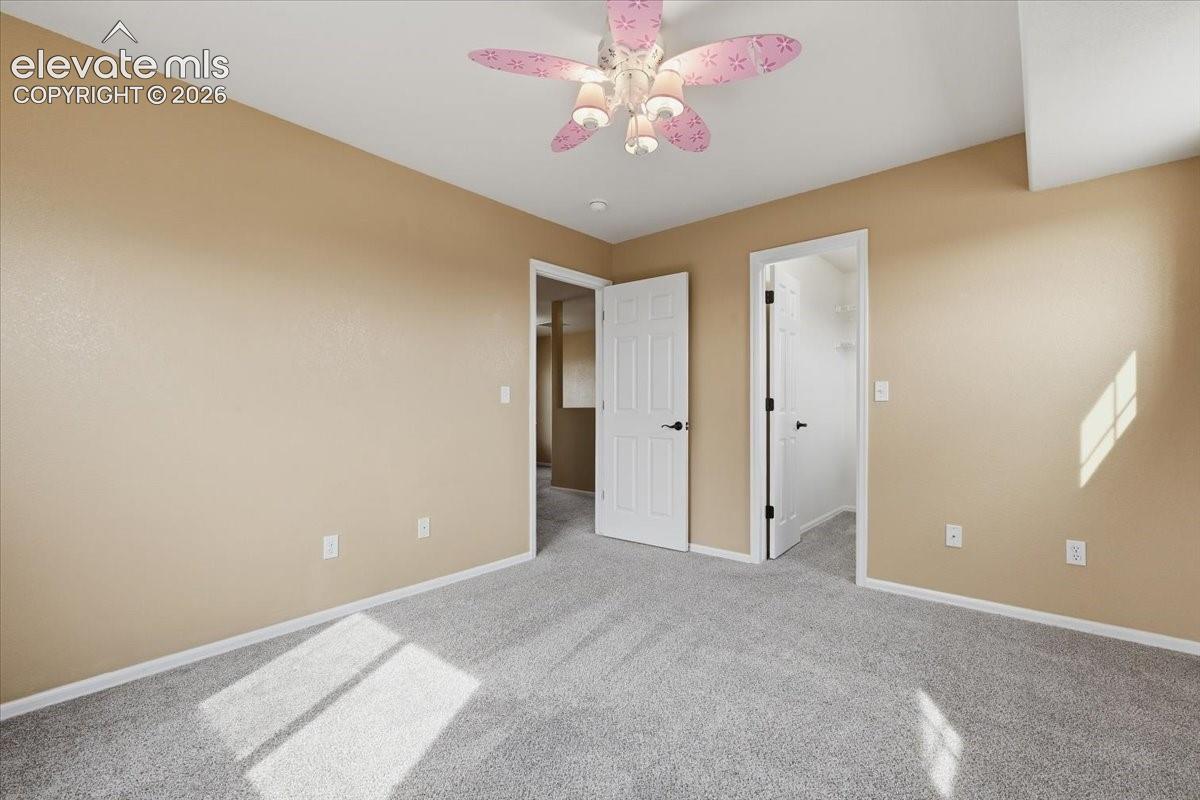 Light gray carpeting, beige wall paint, white trim, and white doors with black hardware