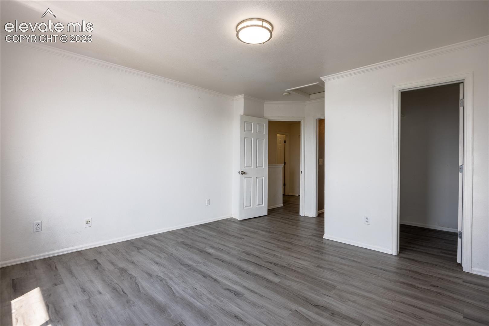 Light gray wood-finish flooring, white walls, and a flush mount ceiling fixture